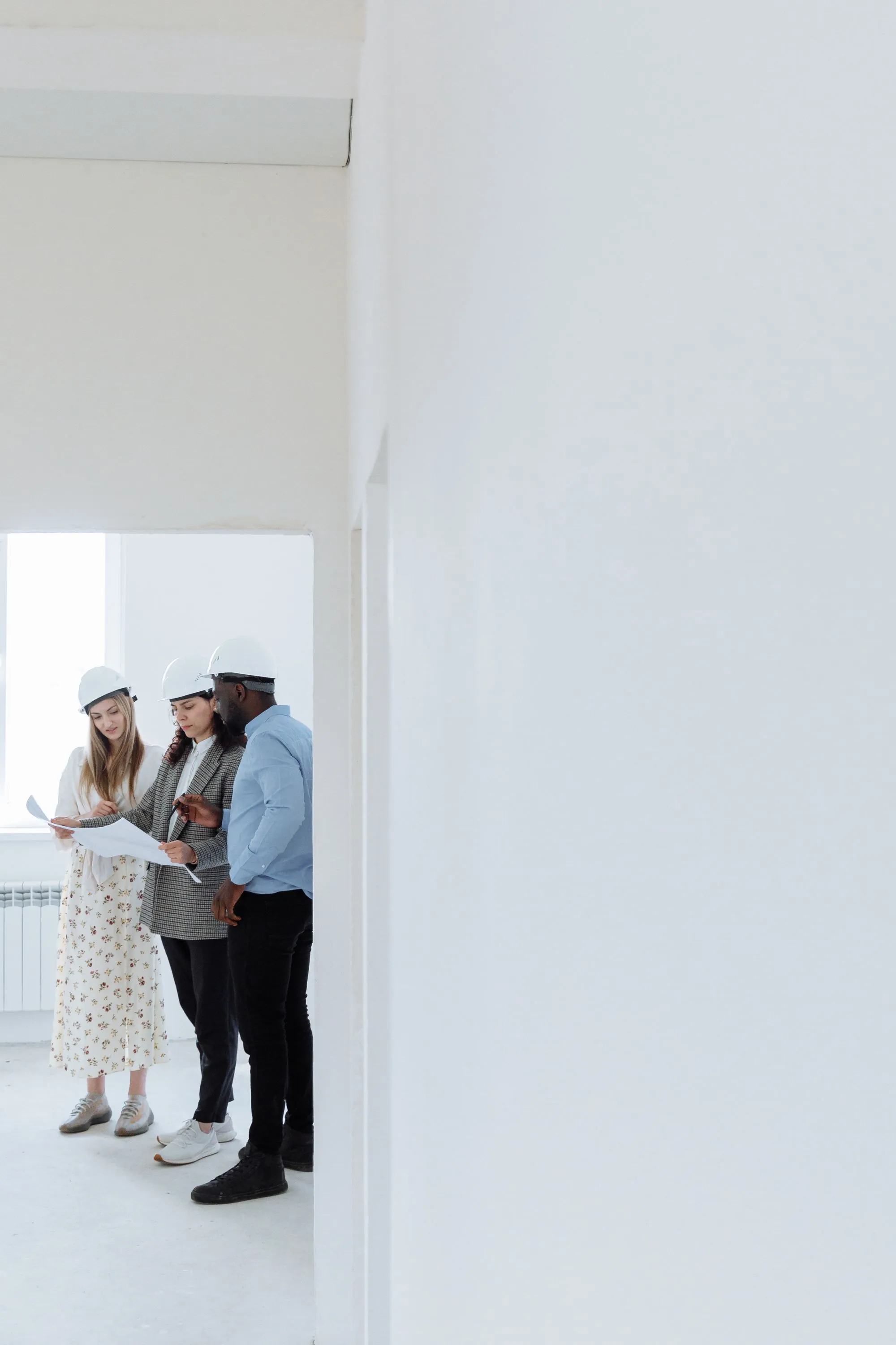 Three workers in hard hats going over a plan on site