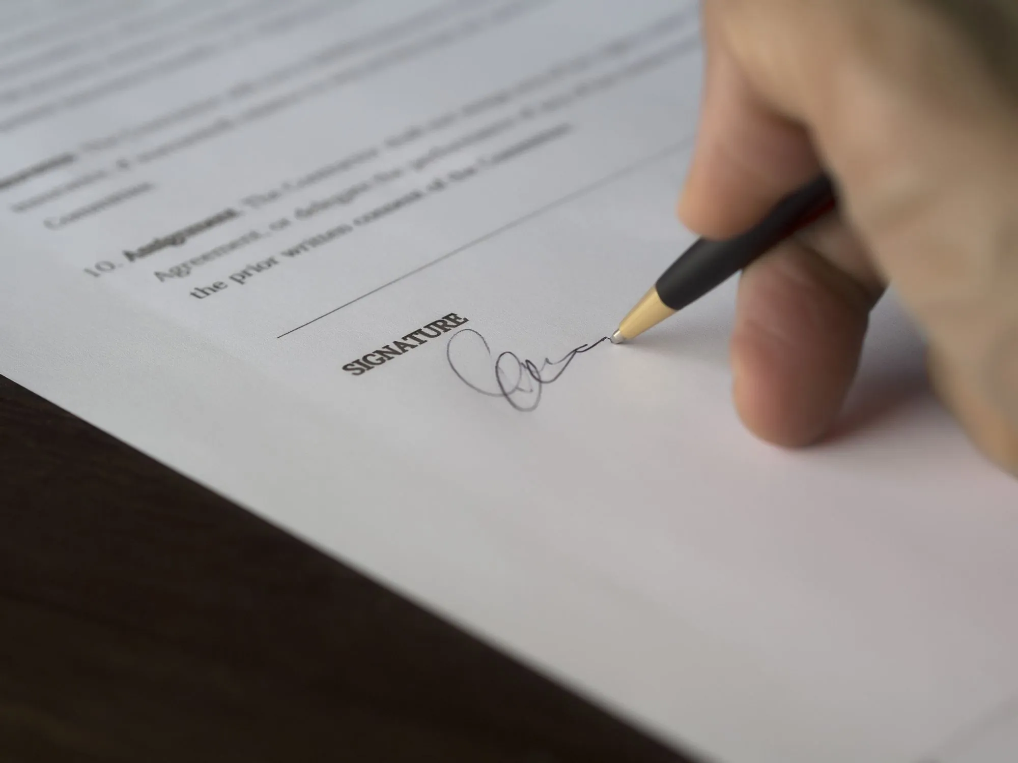 A hand signing a written agreement