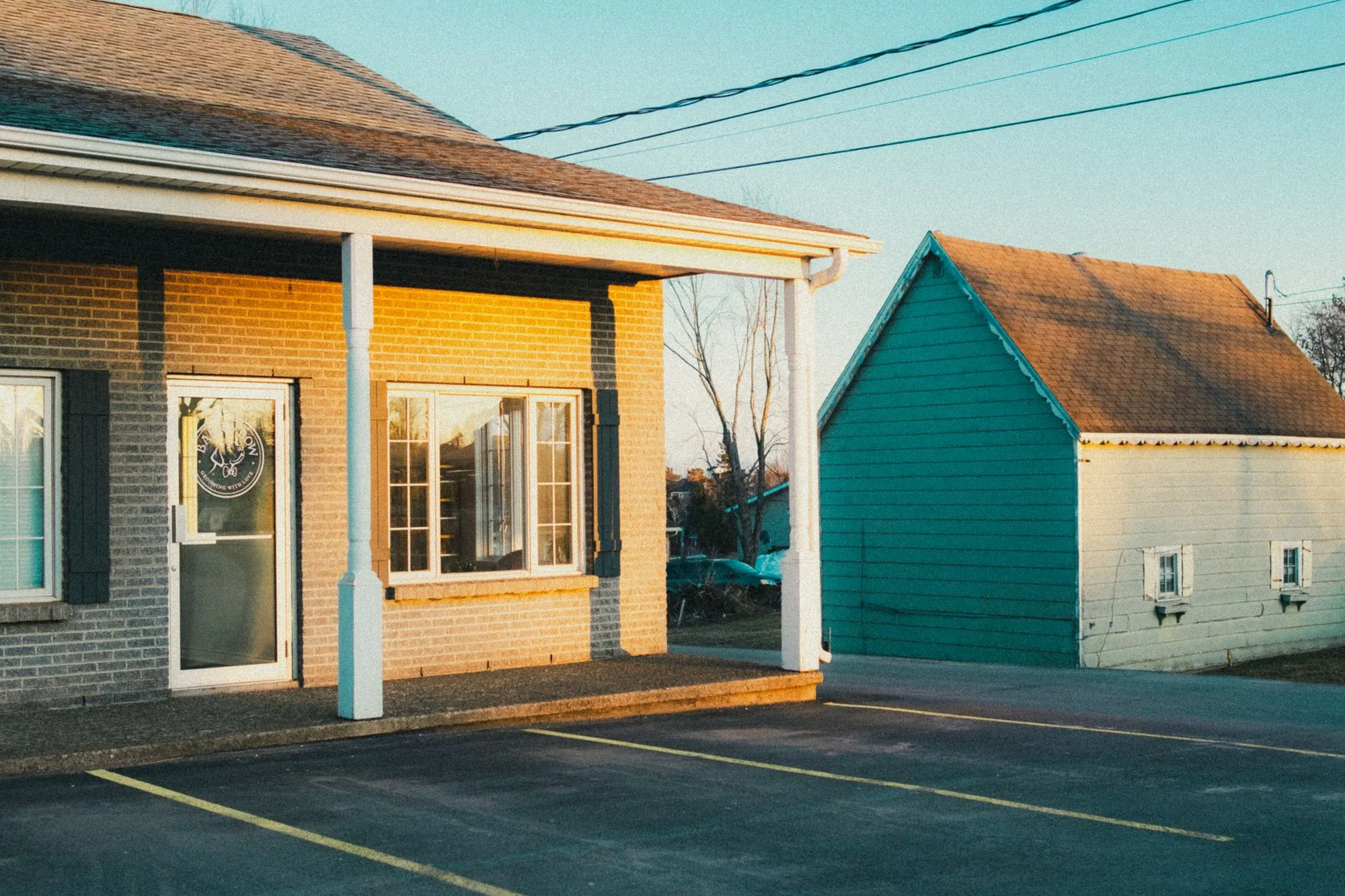 A porch and a clapboard building on a quiet street