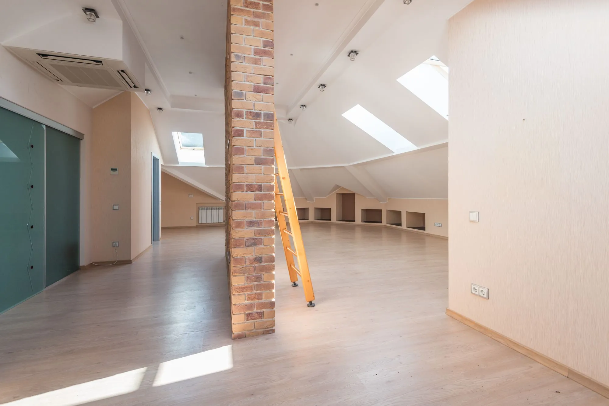 A loft interior with roof timbers and a ladder