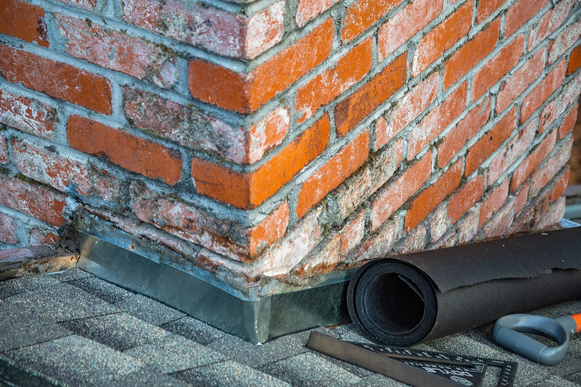 Metal flashing set into brickwork where a roof meets a wall