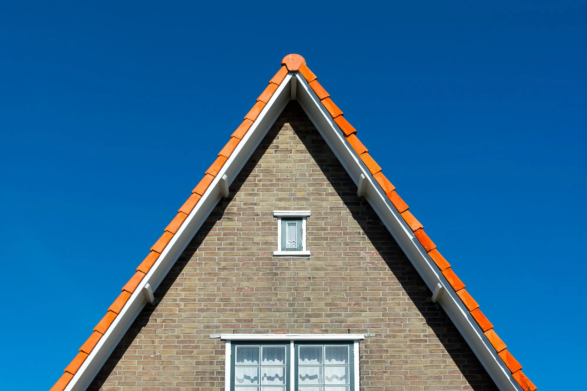 A steep gable roof against a clear sky