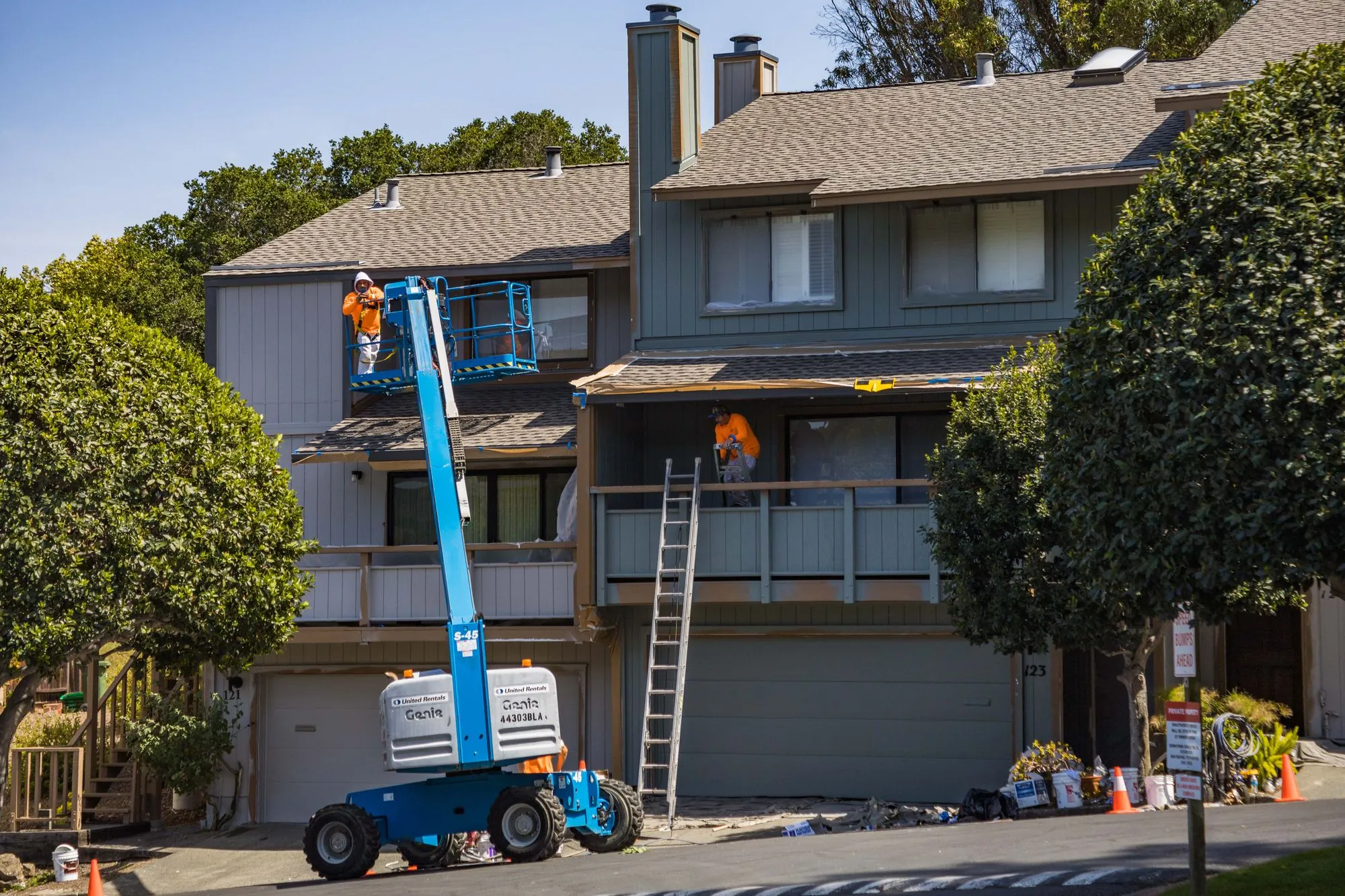 A crew working on the outside of a house from a lift