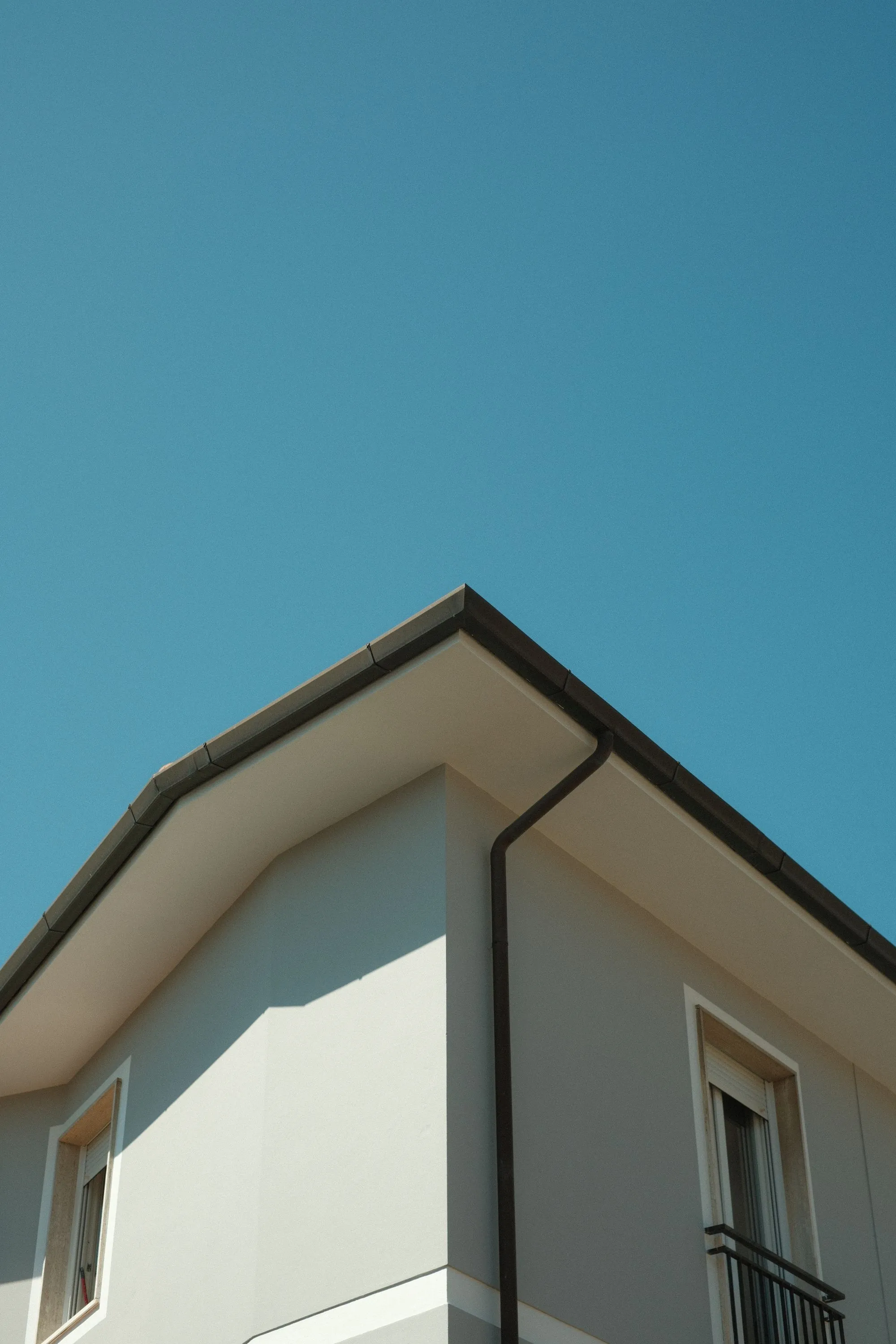 The underside of a roof overhang against a clear sky